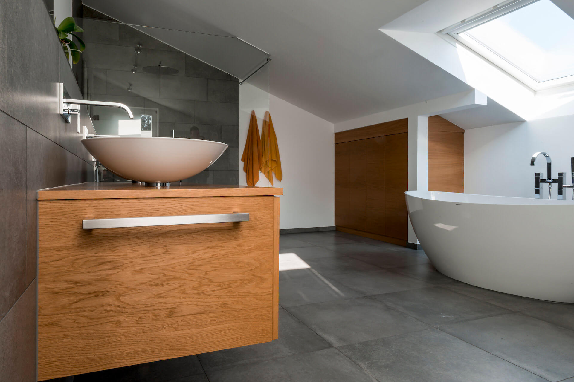 Bad in Eiche Natur mit durchlaufender Maserung mit eleganter Stauraum-Nutzung im Dachgeschoss.