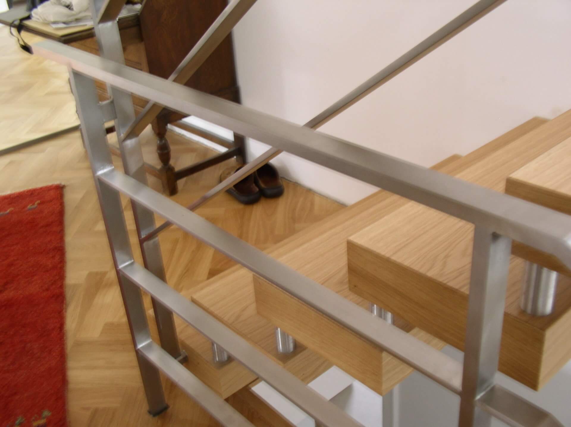 Treppe aus Holz mit Geländer aus Metall Detailansicht